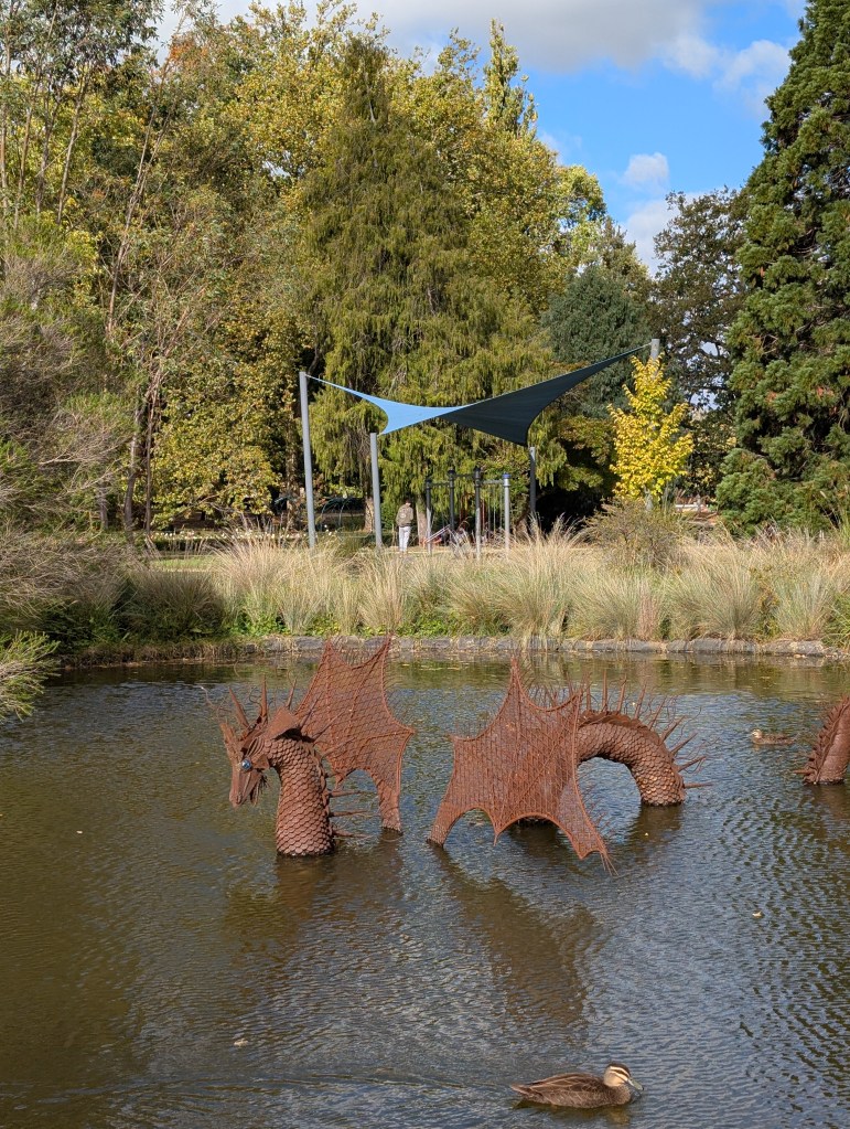 The duckpond at Cook Park, Orange, showing the metal sculpture of "Kevin", a water dragon.