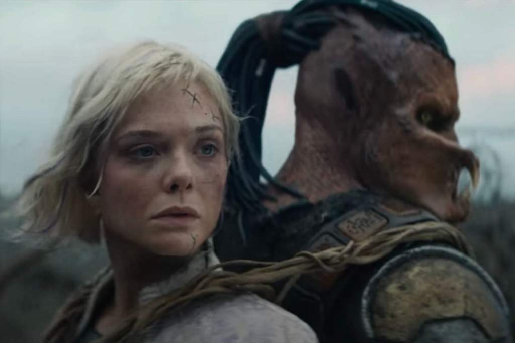 A woman with blonde hair and visible scars on her face gazes intently, while a large, humanoid creature with an imposing posture and distinct features stands closely behind her.